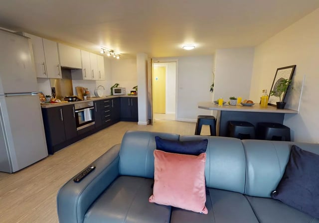 Sofa kitchen island and dining stools living room kitchen at iQ Grosvenor House in Leicester Student Accommodation