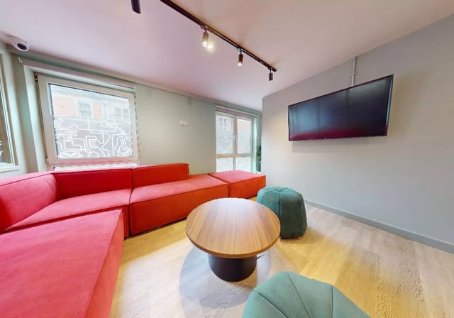 Red sectional sofa coffee table green poufs TV living room at iQ Grosvenor House in Leicester Student Accommodation