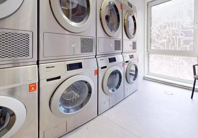Stacked and side-by-side washing machines laundry area at iQ Grosvenor House in Leicester Student Accommodation