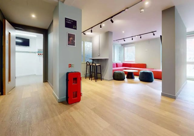 Red fire extinguisher, bar stools, red sofa, seating area at iQ Grosvenor House in Leicester Student Accommodation