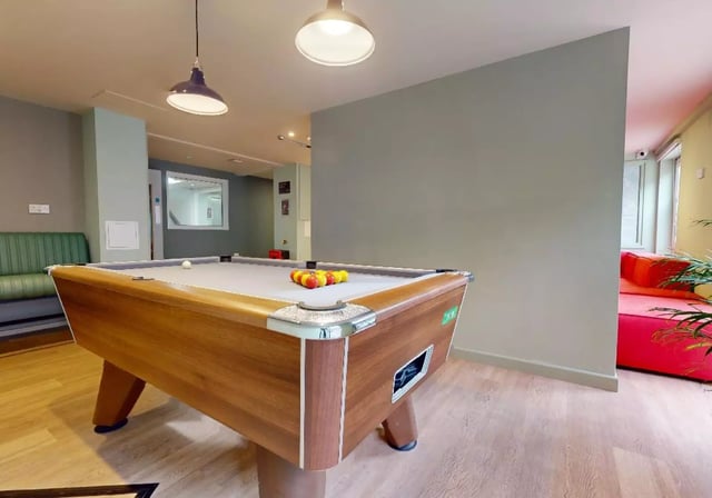 Pool table with balls green couch red couch playing area at iQ Grosvenor House in Leicester Student Accommodation