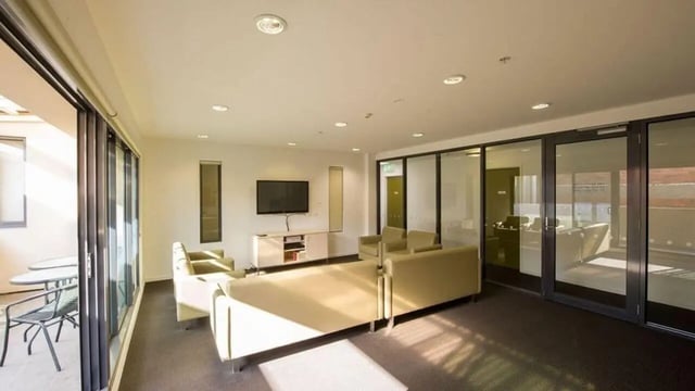 Sofa TV unit and balcony seating common area at Student Living on Cobden in Melbourne Student Accommodation