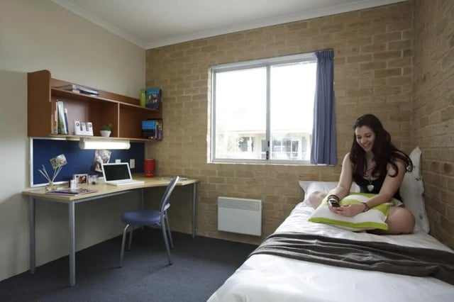 Desk shelf laptop chair bed and woman bedroom at ECU Village Bunbury in Bunbury Student Accommodation