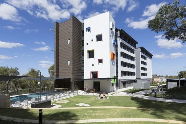 Modern student accommodation buildings pool chairs grass exterior at ECU Village Joondalup in Perth Student Accommodation