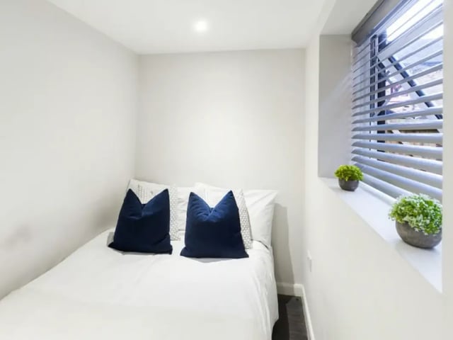 Bed with blue pillows plants window Bedroom at 210 Cauldon Road in Stoke-On-Trent Student Accommodation