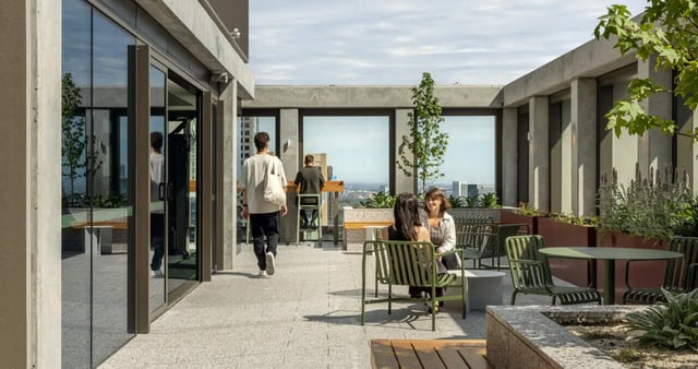 Outdoor lounge area with seating tables and plants at Iglu Melbourne Central in Melbourne Student Accommodation