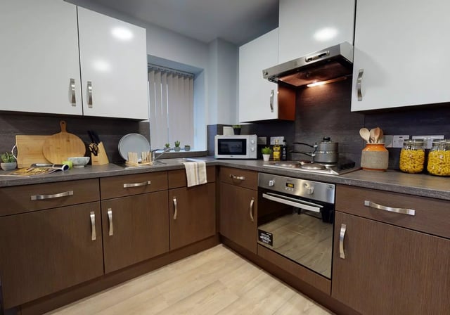White and brown cabinets microwave oven hob kitchen at iQ Penworks House in Birmingham Student Accommodation