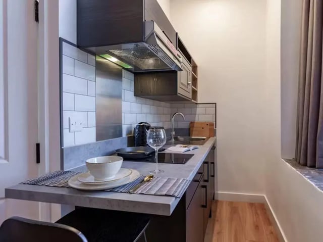 Countertop with dishes sink and cabinets kitchen at The Priory in Leeds Student Accommodation