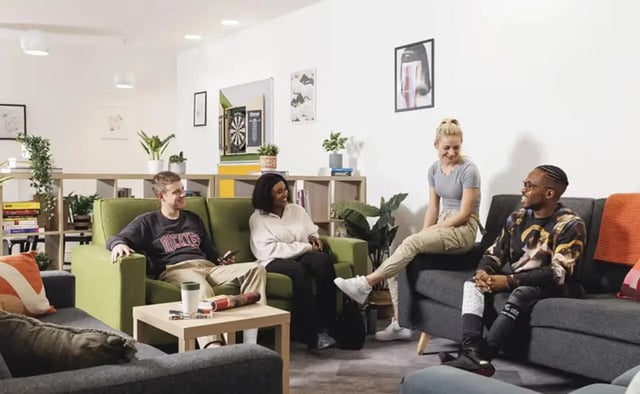 Students relaxing on sofas in common area living room at Concept Place in Leeds Student Accommodation