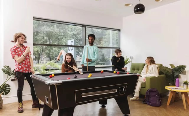 Students playing pool and sitting on sofas living room at Concept Place in Leeds Student Accommodation