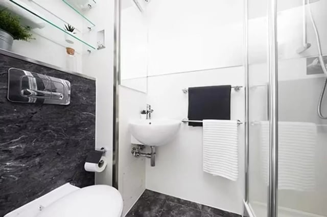 Toilet sink shower towels and shelves bathroom at Sky Plaza in Leeds Student Accommodation