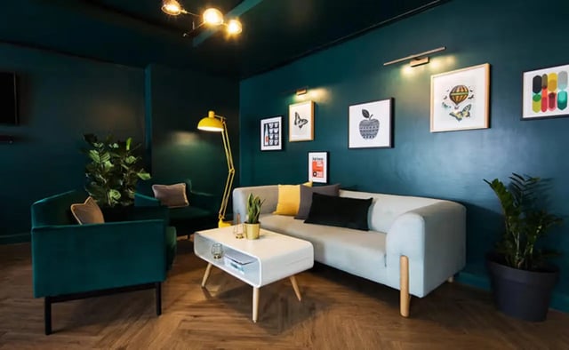 Sofa, chairs, coffee table, plants, art, living room at Sky Plaza in Leeds Student Accommodation