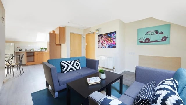 Two sofas coffee table kitchen area living room at Collegiate King Edward Studios in Exeter Student Accommodation