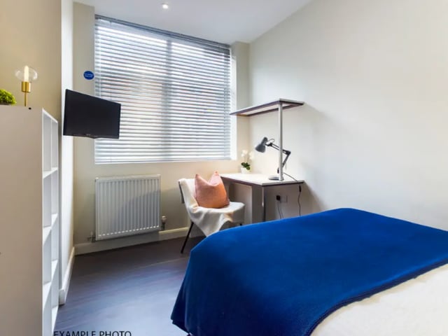 Bed with blue throw desk chair TV Bedroom at 17 Carlton Road in Stoke-On-Trent Student Accommodation