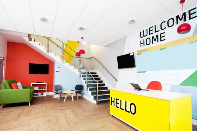 Reception area with desk stairs and lounge area at Arrad House in Liverpool Student Accommodation