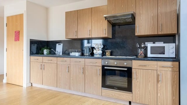 Modern student kitchen with wood cabinets and appliances Kitchen at Collegiate Athena Hall in Ipswich Student Accommodation