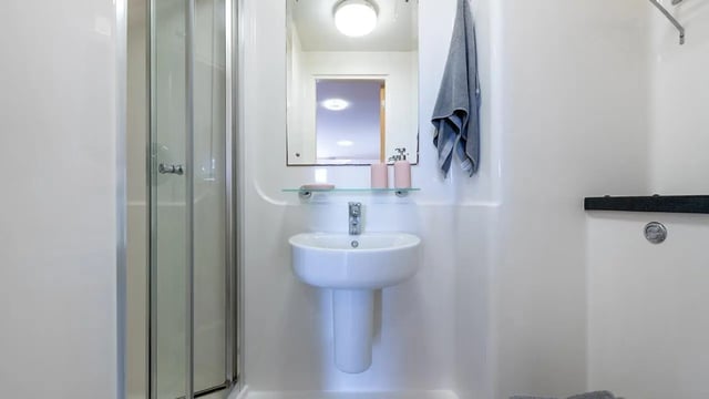 Sink mirror shower door and towel bathroom at Collegiate Athena Hall in Ipswich Student Accommodation