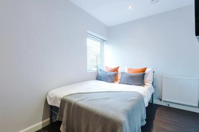 Bed with orange grey pillows radiator bedroom at 9 Queen Anne Street in Stoke-On-Trent Student Accommodation
