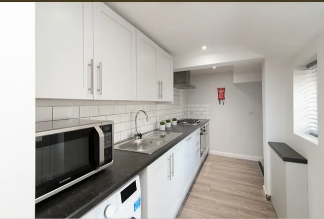 Microwave sink hob cabinets tiling and washing machine kitchen at 9 Queen Anne Street in Stoke-On-Trent Student Accommodation