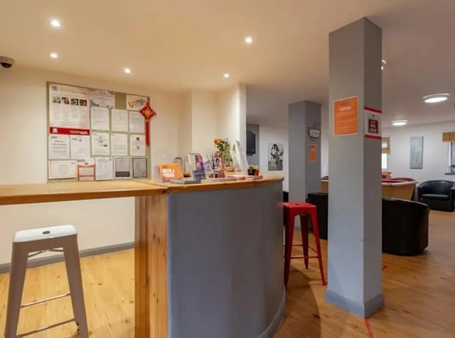 Reception desk with notice board and stools common area at The Print House in Loughborough Student Accommodation