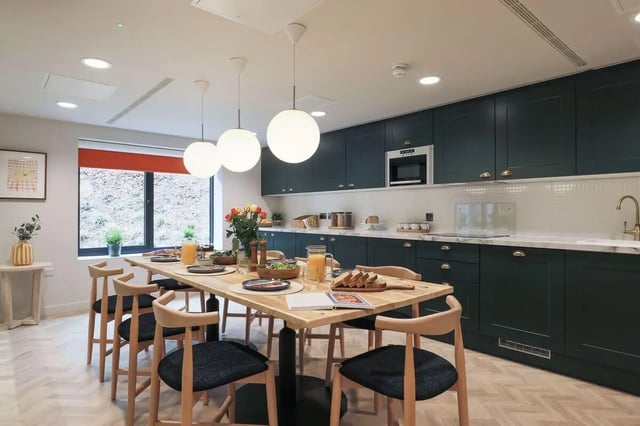 Dining table with chairs and kitchen area kitchen at St Mark's Court in Leeds Student Accommodation