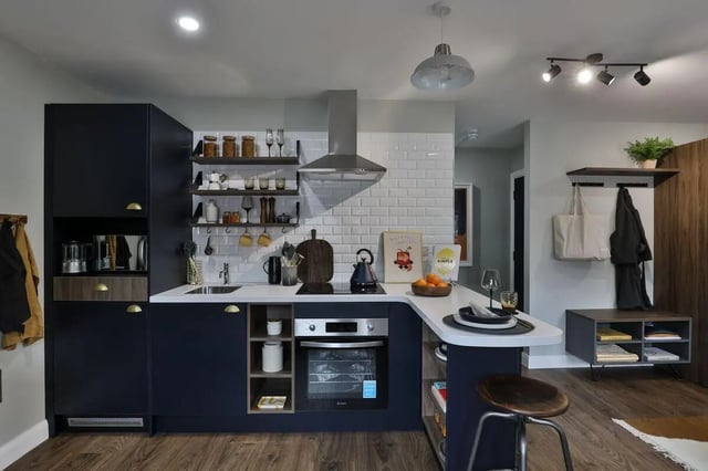 Modern kitchen with dark cabinets stove and seating kitchen at St Mark's Court in Leeds Student Accommodation