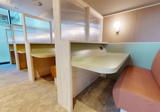 Desks with partitions and orange seating study area at iQ Aldgate in London Student Accommodation