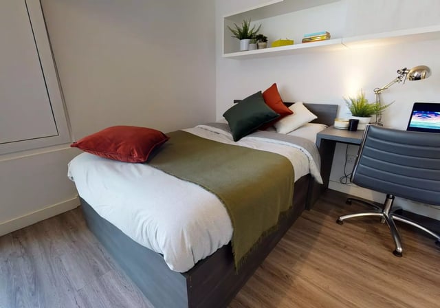 Bed desk chair and laptop bedroom at iQ Aldgate in London Student Accommodation