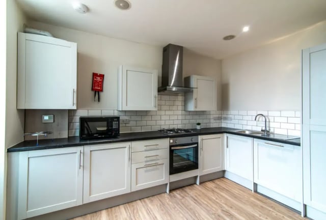 Modern white cabinets microwave stove sink kitchen at 18 Cauldon Road in Stoke-On-Trent Student Accommodation