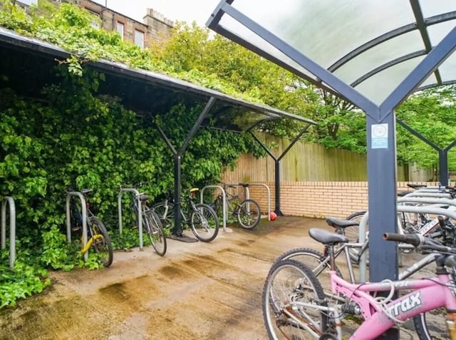 Bicycles parked under green ivy covered shelter exterior at Beaverbank Place in Edinburgh Student Accommodation