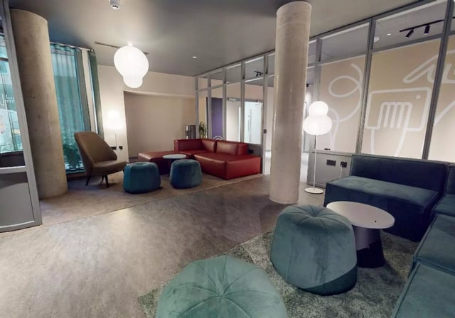 Red sofa, beanbags, armchairs, coffee table living area at iQ City in London Student Accommodation