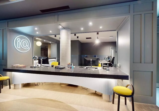 Reception desk with computers and iq logo reception area at iQ City in London Student Accommodation