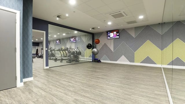 Gym equipment with exercise balls and TVs gym at Collegiate Crown Place Norwich in Norwich Student Accommodation