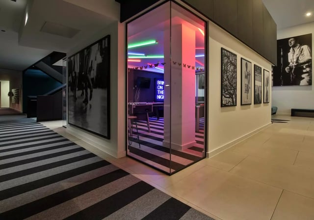 Glass room with neon lights and foosball table common area at iQ Hammersmith in London Student Accommodation