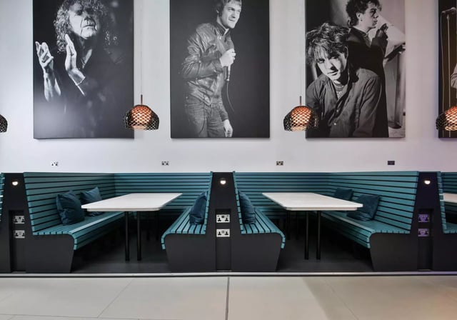 Booths with tables pillows and wall art dining area at iQ Hammersmith in London Student Accommodation