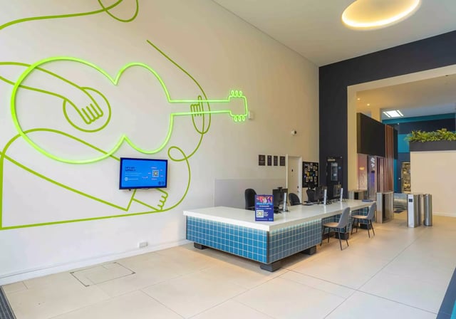 Reception desk with computers and guitars artwork exterior at iQ Hammersmith in London Student Accommodation
