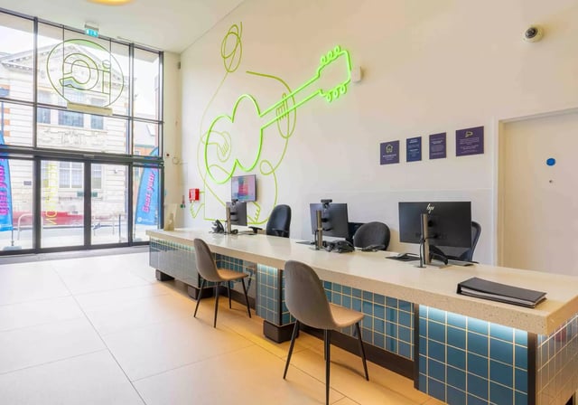 Reception desk with computers and chairs reception area at iQ Hammersmith in London Student Accommodation