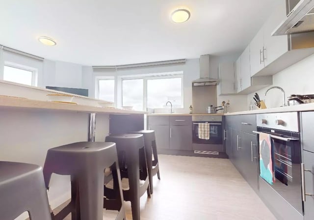 Stools by counter with ovens and sink kitchen at iQ Highbury in London Student Accommodation