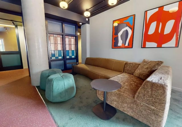 Brown sofas green ottomans art living room at iQ Highbury in London Student Accommodation