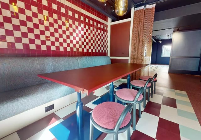 Red table grey bench checkered wall seating area at iQ Highbury in London Student Accommodation