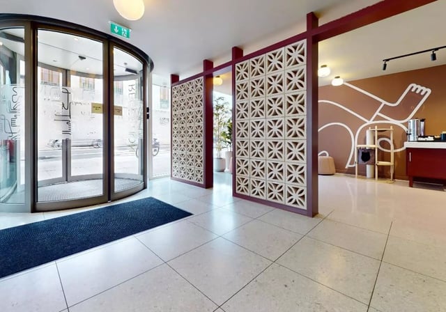 Entrance lobby with revolving door cat tree and mural lobby at iQ Highbury in London Student Accommodation