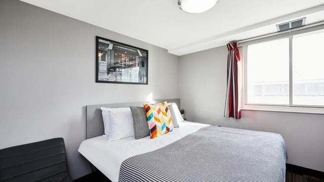 Bed with colorful pillows and striped throw Bedroom at The Moor in Sheffield Student Accommodation