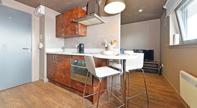Modern kitchen with white table and chairs living room at Marketgait Apartments in Dundee Student Accommodation