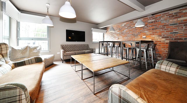 Sofas tables bar stools TV living room at Marketgait Apartments in Dundee Student Accommodation