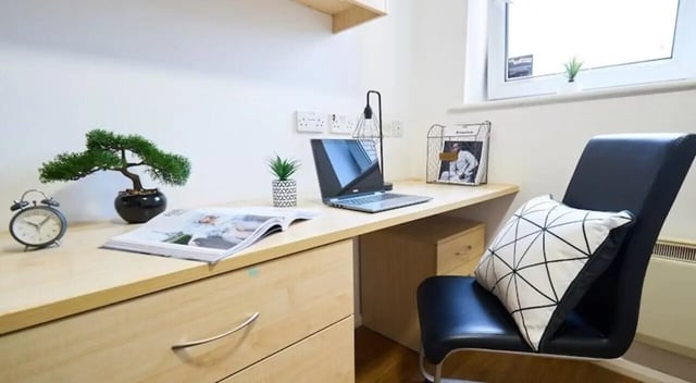 Desk with laptop bonsai clock chair study area at Manchester House in Manchester Student Accommodation