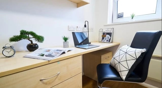 Desk with laptop bonsai plant chair study area at Manchester House in Manchester Student Accommodation