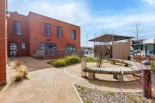 Courtyard with curved benches and brick building exterior at Atlas House in Exeter Student Accommodation