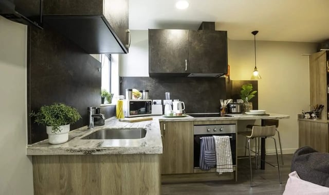 Modern kitchen with counter microwave sink and oven kitchen at St Peter's Hall in Bournemouth Student Accommodation
