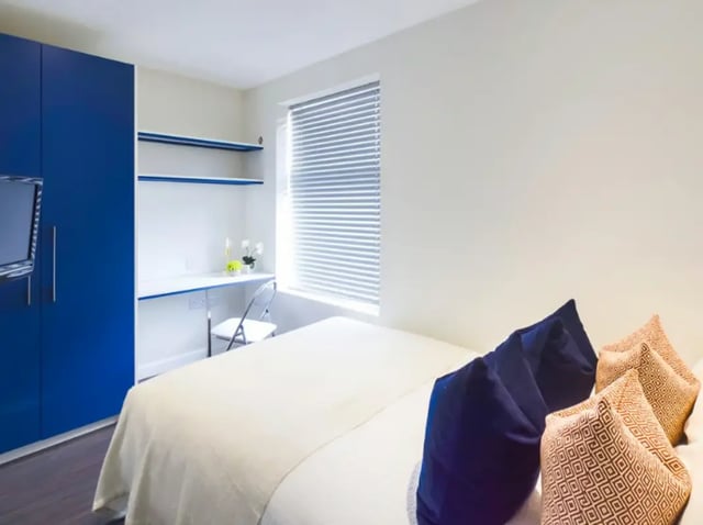 Blue wardrobe desk white shelves bed bedroom interior at 23 Carlton Road in Stoke-On-Trent Student Accommodation
