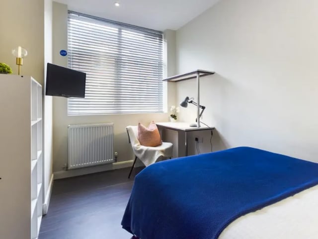 Bed blue blanket desk chair radiator TV bedroom at 23 Carlton Road in Stoke-On-Trent Student Accommodation